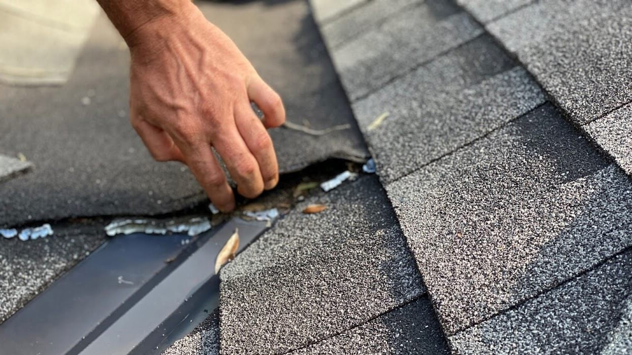 lifting shingles during roof inspection